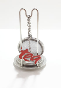 An Unused Tea Ball Strainer / Infuser With Stand, Tray & Red Enamelled “Tea” Charm