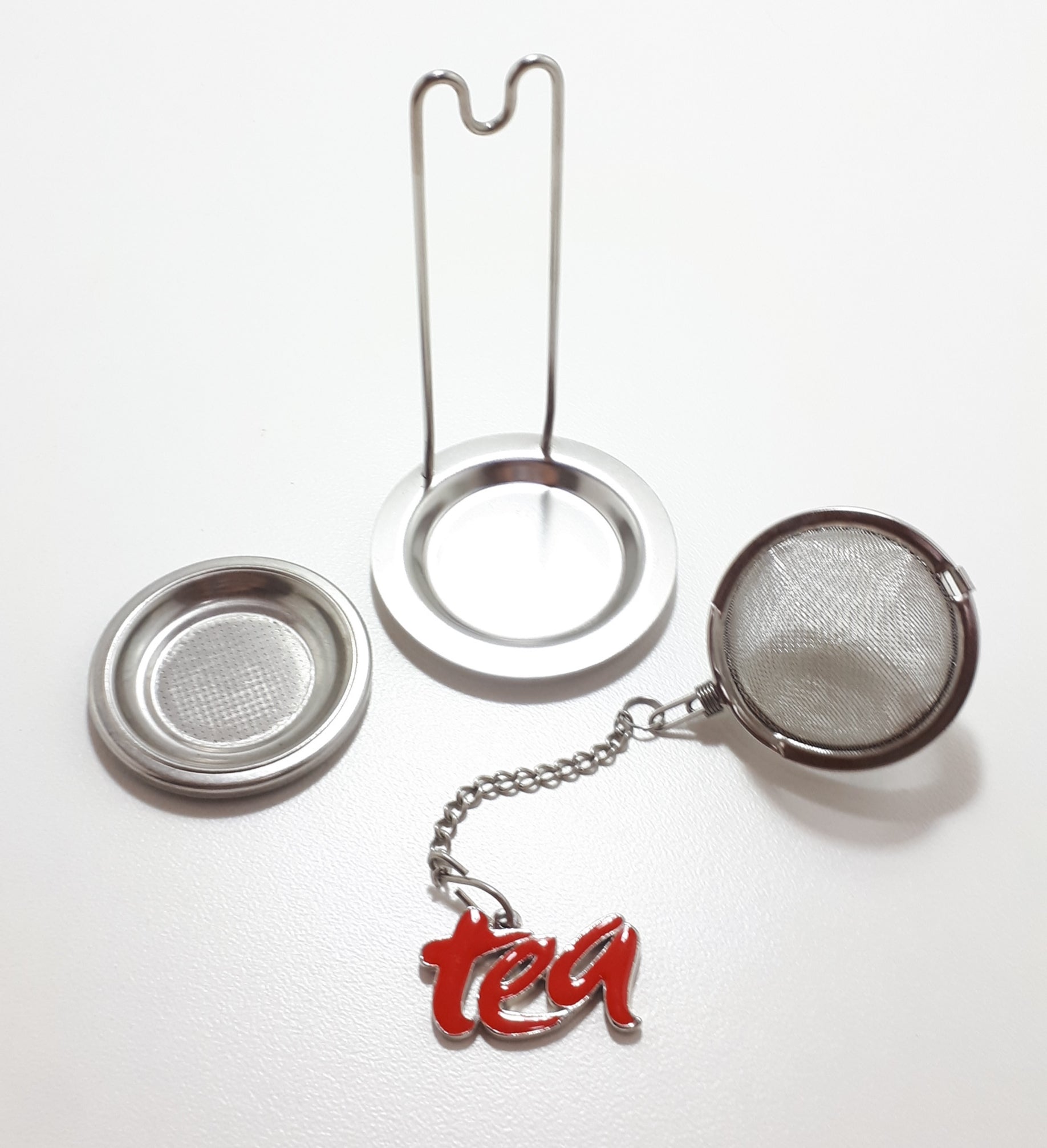 An Unused Tea Ball Strainer / Infuser With Stand, Tray & Red Enamelled “Tea” Charm