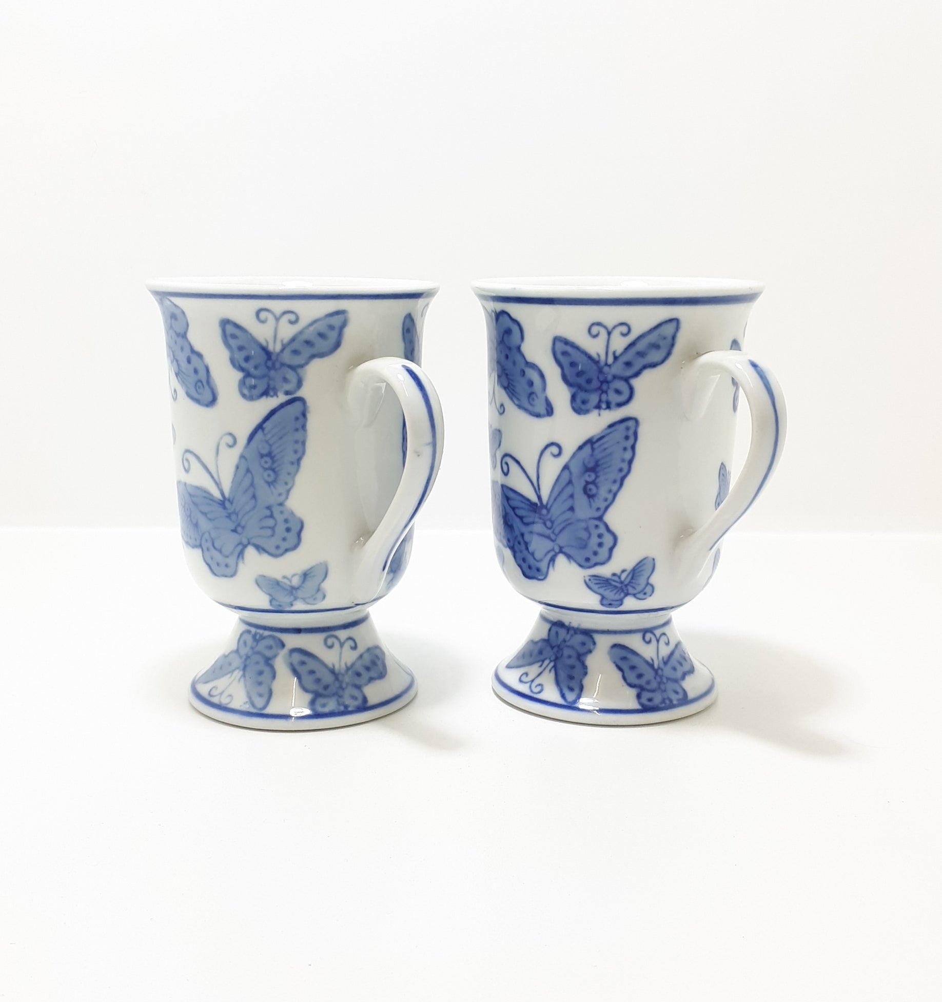Pair Of Blue & White Footed Coffee Mugs With Butterfly Decoration